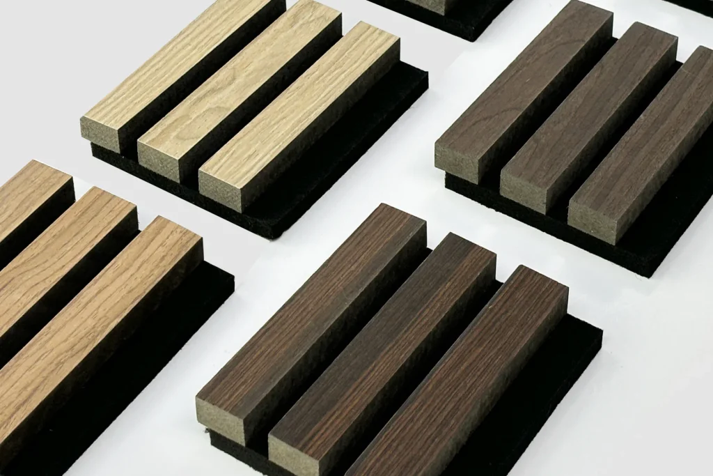 Rectangular wooden blocks in different shades arranged in rows on black bases, displayed on a white background. The blocks form a grid pattern and showcase varying wood textures and colors.