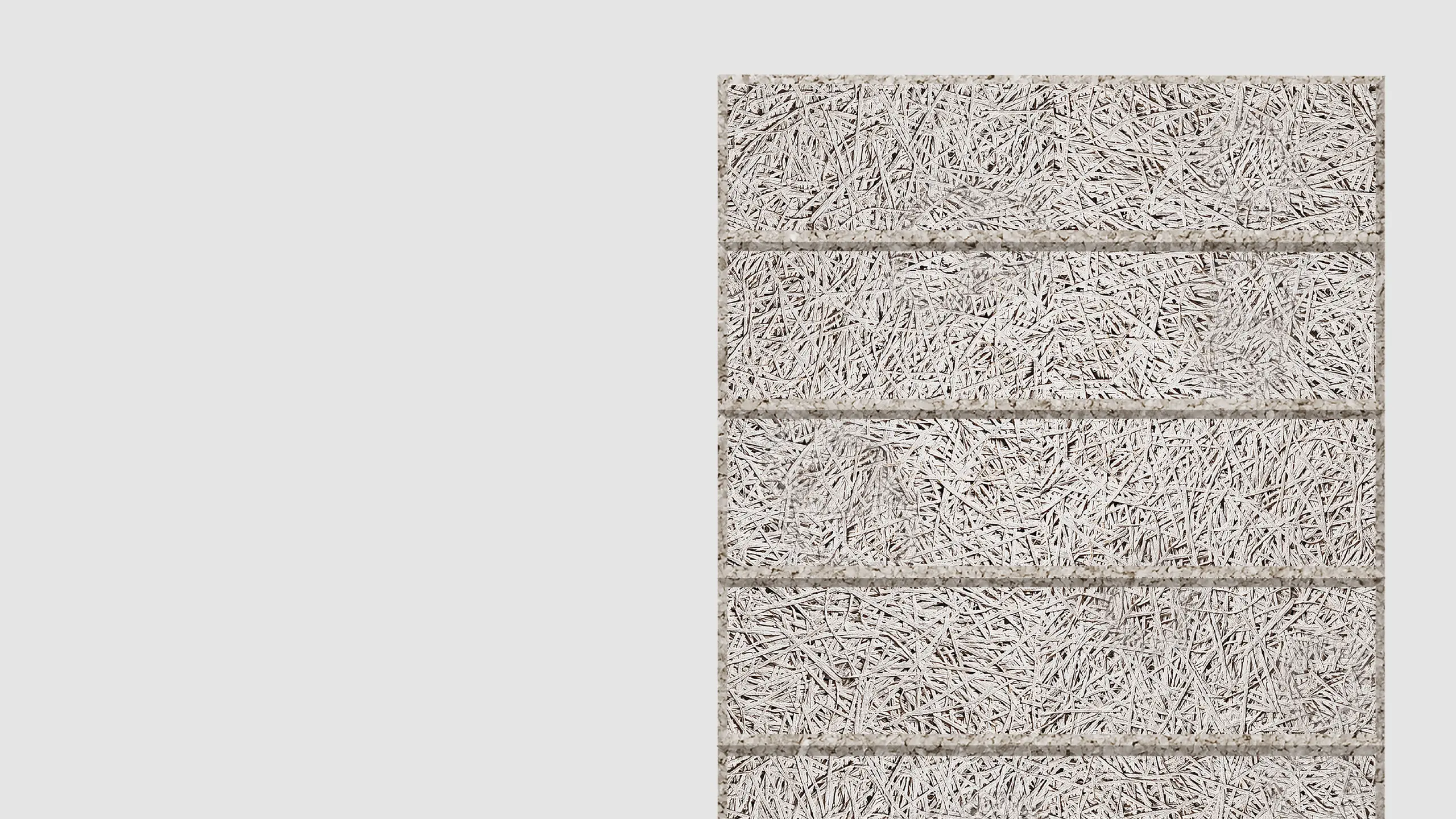 Close-up view of a light gray textured wall panel made of compressed wood wool fibers, divided by horizontal grooves into four sections, with a plain light gray background on the left.
