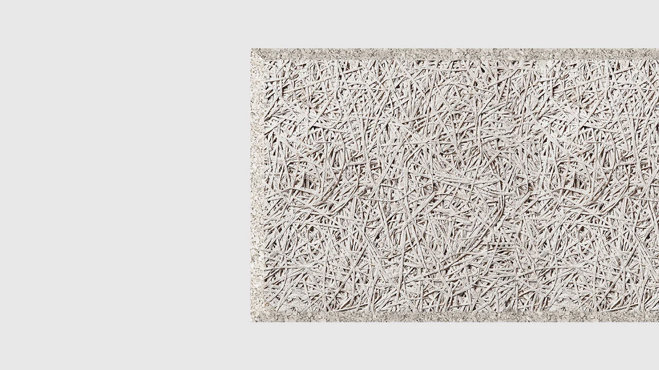 A close-up of a rectangular panel with a dense, tangled texture made of thin, pale wood fibers pressed together, set against a plain white background.