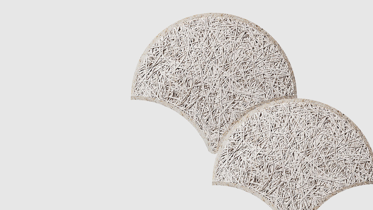 Two textured, semi-circular panels with a rough, fibrous surface overlap slightly on a plain, light background. The panels appear off-white and have an organic, woven appearance.