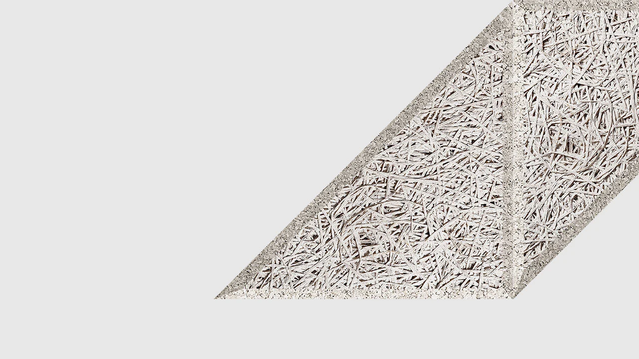 A textured, diagonal geometric shape with a rough, straw-like surface pattern on a plain white background. The shape is partially cropped on the right side.