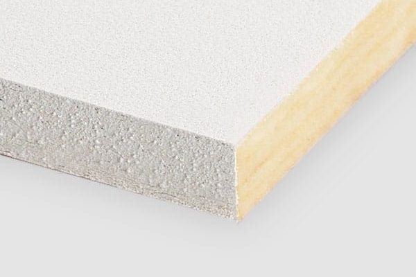 A close-up of the corner of a rectangular, white laminated board showing its layered structure with a smooth white surface and a wooden core. The background is plain and light gray.