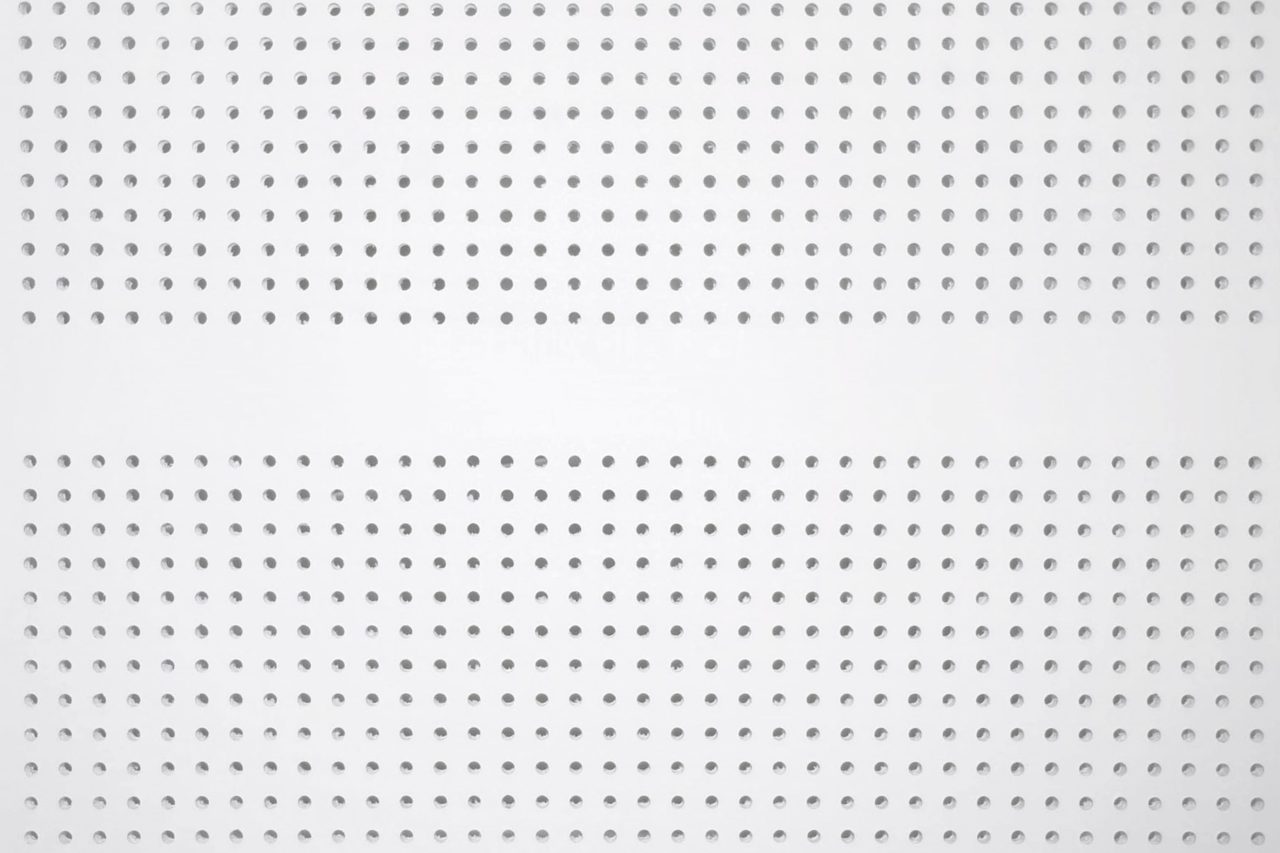A white perforated metal panel with evenly spaced round holes arranged in horizontal rows, creating a uniform geometric pattern across the surface.