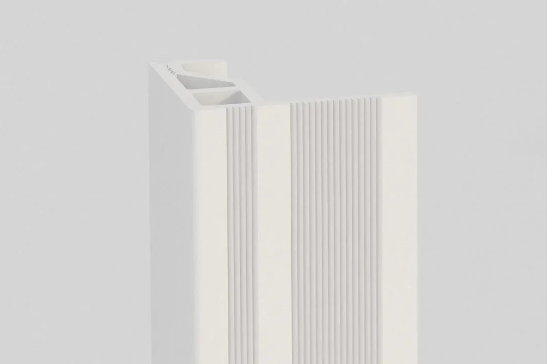 A close-up of a white, rectangular plastic or metal extrusion with vertical grooves and a hollow interior, set against a light grey background.