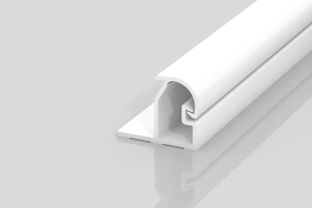 A white, L-shaped plastic or metal trim piece with a flat base and a rounded top is shown on a plain light gray background. The trim features a grooved inner section and smooth surfaces.