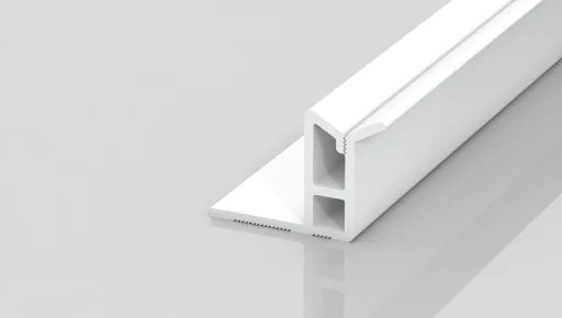 A white, T-shaped plastic or metal profile piece with two hollow rectangular sections, resting on a reflective light gray surface.