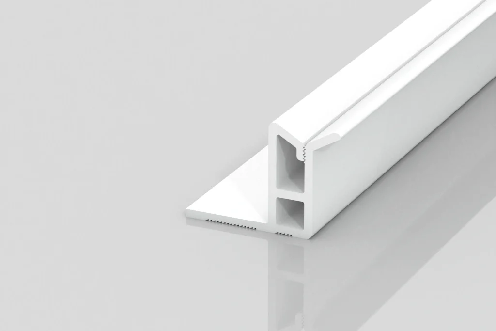 A white, T-shaped plastic or metal profile piece with two hollow rectangular sections, resting on a reflective light gray surface.