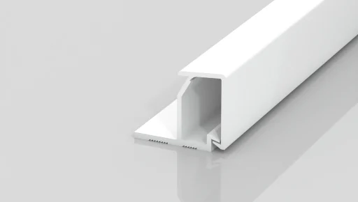 A white, rectangular plastic or metal channel with an open slot and a flat base sits on a glossy, light gray surface, showing a minimal, modern design.