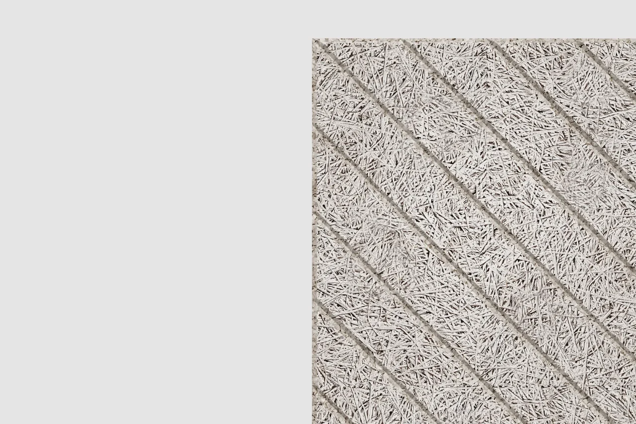 A rectangular panel with a textured surface made of compressed wood fibers, featuring diagonal grooves evenly spaced across the panel. The background is plain light gray.