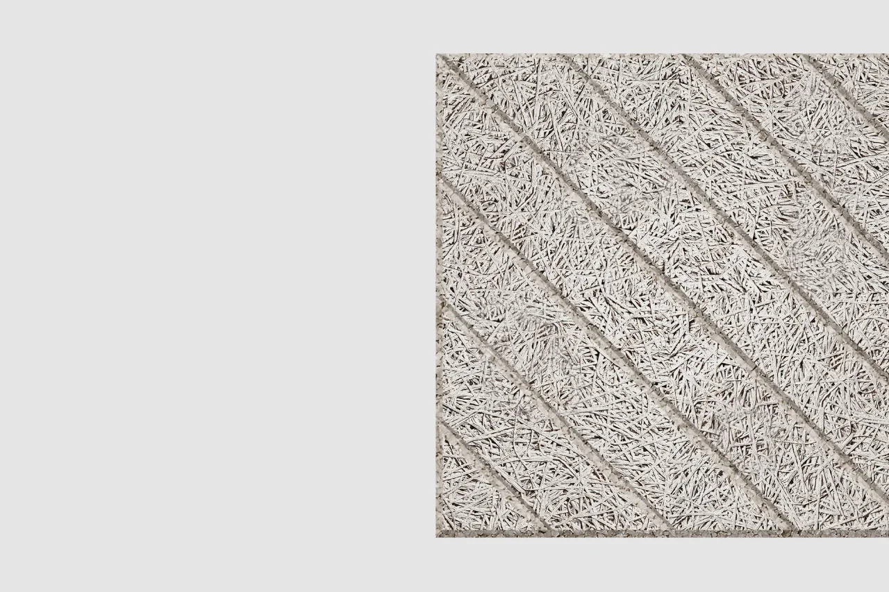A close-up view of a square, textured panel featuring diagonal, grooved lines and a rough, straw-like surface pattern on a light gray background.