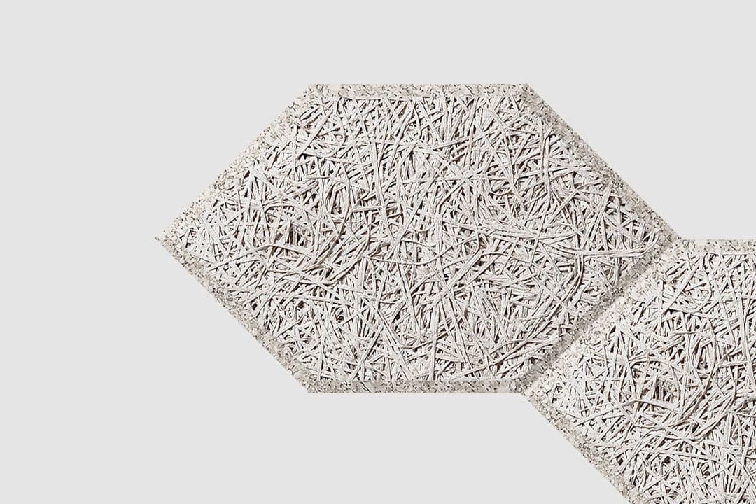 Two light gray hexagonal panels with a textured, fibrous surface pattern overlap slightly on a plain white background.